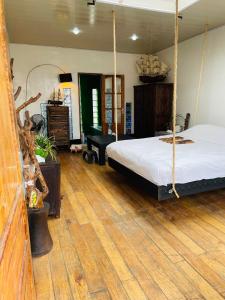 1 dormitorio con cama colgante y suelo de madera en Bamboo Lodge en Antananarivo