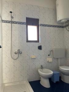a bathroom with a shower and a toilet and a window at Pararse Apartments in Vlorë +45 photos