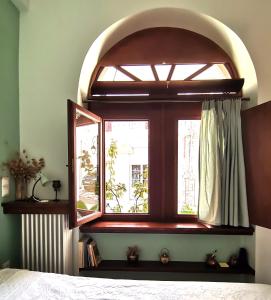 a bedroom with a window with an archway at Ξενώνας Μυρτώ in Andritsaina