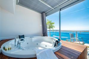 a bath tub in a room with a view of the ocean at PEARLY HOTEL in Antalya +47 photos