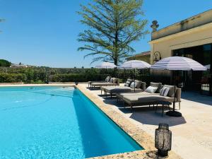 聖埃斯泰夫的住宿－Château Laffitte Carcasset，房屋旁的游泳池配有躺椅和遮阳伞