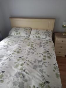 a bed with a white bedspread with flowers on it at Jack's House in Glenties
