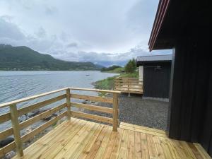 une terrasse en bois à côté d'une masse d'eau dans l'établissement Fagervik Camping, à Tresfjord