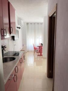 a kitchen with pink cabinets and a sink and a table at RedStudio Torremolinos in Torremolinos