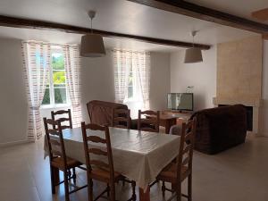 GauriacにあるMAISON avec 2 logements indépendantsのテーブルと椅子とテレビのあるダイニングルーム