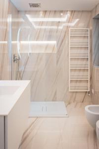 a white bathroom with a sink and a toilet at Seaside Resort in Trieste