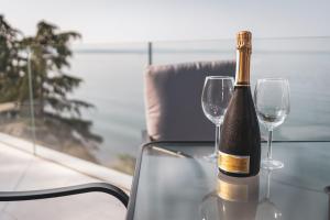 a bottle of wine sitting on a table with two wine glasses at Seaside Resort in Trieste