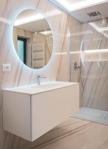ein Badezimmer mit einem weißen Waschbecken und einem Spiegel in der Unterkunft Seaside Resort in Triest