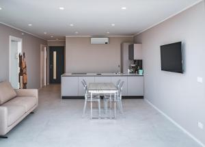 a kitchen and living room with a table and a couch at Seaside Resort in Trieste