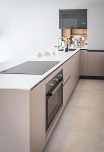 a white kitchen with a sink and a refrigerator at Seaside Resort in Trieste