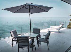 a patio with a table and chairs and an umbrella at Seaside Resort in Trieste