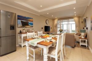 uma cozinha e sala de jantar com mesa e cadeiras em Pinnacle Point 2-bedroom self-catering apartment em Mossel Bay