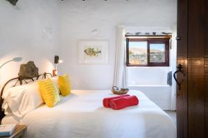 Mácher的住宿－La Casa del Medianero，一间卧室配有白色的床和黄色及红色枕头