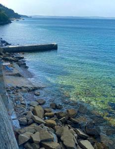 una playa con rocas y agua en el océano en Seaside Resort en Trieste