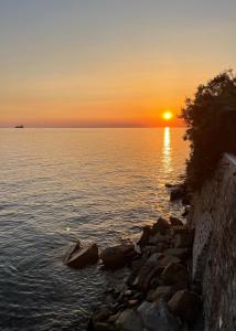 a sunset over a body of water with rocks at Seaside Resort in Trieste