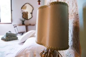 a brown lamp sitting on top of a bed at Tenuta San Rocco in Conzano