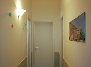 un corridoio con una porta e una luce sul muro di Dimoramare a Tonnara di Bonagia