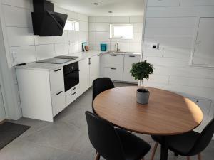 uma cozinha com uma mesa de madeira e cadeiras pretas em New villa, 45sqm, 2 bedrooms, loft, 80m from beach, fantastic views & very quiet area em Onsala