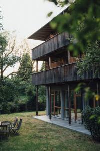 滨湖上特鲁姆Pension Obertrum am See的一位女士坐在建筑物前的长椅上