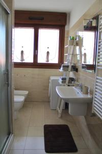 a bathroom with a sink and a toilet and windows at Rho Fiera Milano - Popy House in Pero