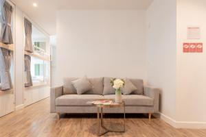 a living room with a couch and a table with flowers at Lanna Bonita Boutique Hotel in Chiang Mai