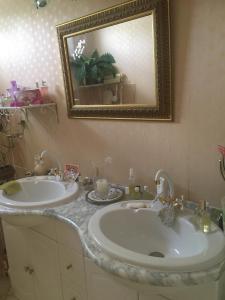 uma casa de banho com 2 lavatórios e um espelho em Le Havre de paix em Saint-Cyr-sur-Loire