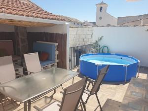 un patio con mesa y sillas y una piscina en Casa El Forestal, en Arbuniel