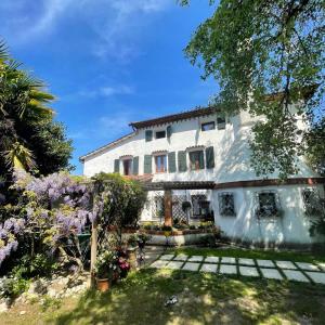 a large white house with flowers in the yard at La Bricola in Cavallino-Treporti