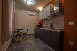 une cuisine avec un comptoir, une table et des chaises dans l'établissement Via Cavour 19, Appartamento del Conte, à Iglesias