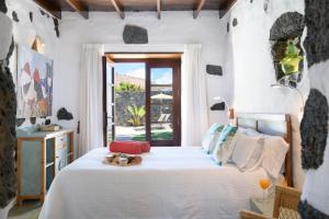 a bedroom with a bed with white sheets and a window at La Casa del Medianero in Mácher