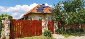 uma casa com painéis solares em cima de uma cerca em Barackos Apartman em Tapolca