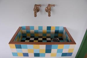ein Waschbecken mit 2 Armaturen und einem Waschbecken mit Schachbrettmuster in der Unterkunft Treetop Apartment in Den Haag