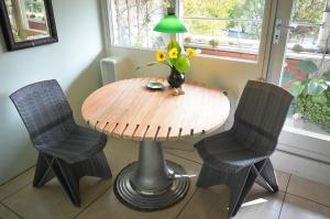 d'une table avec deux chaises et d'un vase avec des fleurs. dans l'établissement Treetop Apartment, à La Haye