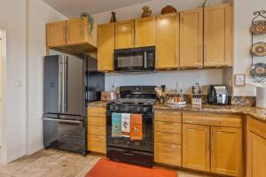 a kitchen with wooden cabinets and a black stove at Close to Fresh Creek! Sleeps 12 ~ Amazing Views w/Serene Open Space ~ Hot Tub + Game Room ~ Trails outside in Sedona