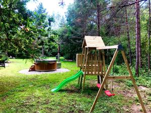 a wooden playground with a slide and a swing at Kibuvitsa Holiday House in Muratsi