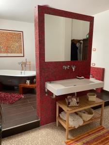 uma casa de banho com um lavatório, um espelho e uma banheira em La casa dei caprioli appartamento in casale em Montepulciano