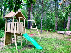 a playground with a slide and a tree house at Kibuvitsa Holiday House in Muratsi
