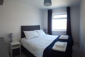 een slaapkamer met een bed met twee handdoeken erop bij Bungalow by the sea in Hunstanton