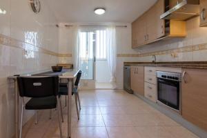 eine Küche mit einem Tisch und einigen Stühlen in der Unterkunft LUXURY Townhouse in Gran Alacant, Alicante in Gran Alacant