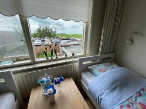 a small bedroom with a window and a table at Huis bij het water in uitstekend fiets-, vis- en vaargebied in Jutrijp