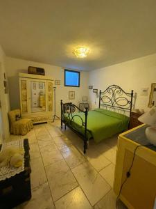 um quarto com uma cama verde num quarto em La casa dei caprioli appartamento in casale em Montepulciano