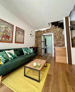 a living room with a green couch and a table at Suite 29A Olbia Center in Olbia