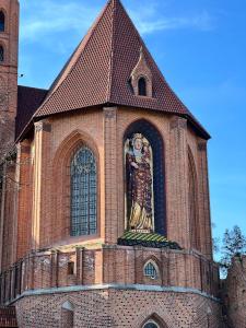 Kościół z posągiem na boku w obiekcie Castle View Apartment w mieście Malbork