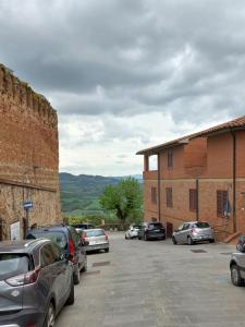 a parking lot with cars parked next to a brick building at Poppy's House in Casole dʼElsa