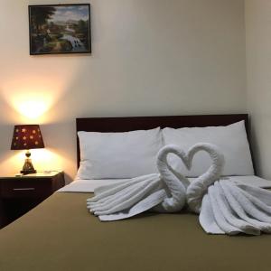a bed with two towels in the shape of swans at Drew Hostel in Tagbilaran City