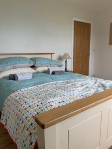un grande letto con una trapunta colorata sopra di Causeway Cottage a Newcastle