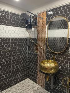 La salle de bains est pourvue de toilettes dorées et d'un miroir. dans l'établissement Sunshine Bay Resort Beachaholic Homestay, à Port Dickson