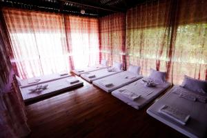 a room with four beds in front of a window at Không gian văn hóa trà Suối Giàng in Văn Chấn