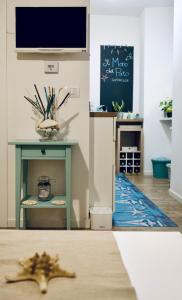 a living room with a table with a tv on a wall at Il Mono del Porto - Studio Apartment in Ancona