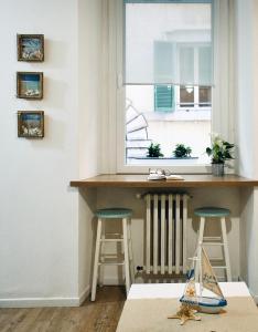 eine Küche mit einer Theke und zwei Hockern unter einem Fenster in der Unterkunft Il Mono del Porto - Studio Apartment in Ancona